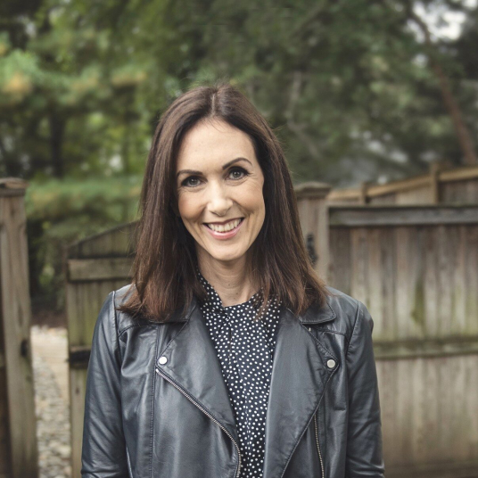 A woman wearing a leather jacket and polka dot shirt.