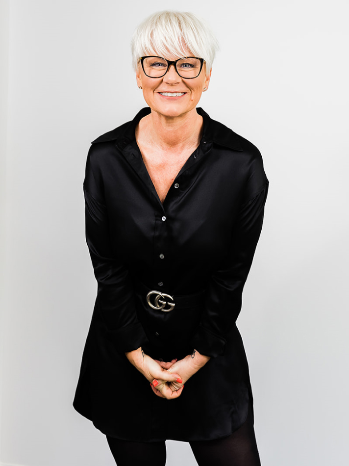 A woman wearing glasses and a black dress.