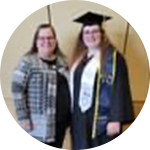 Two women in graduation gowns standing next to each other.